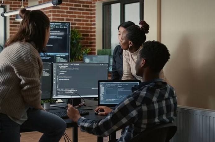 Team reviewing code together at a shared desk